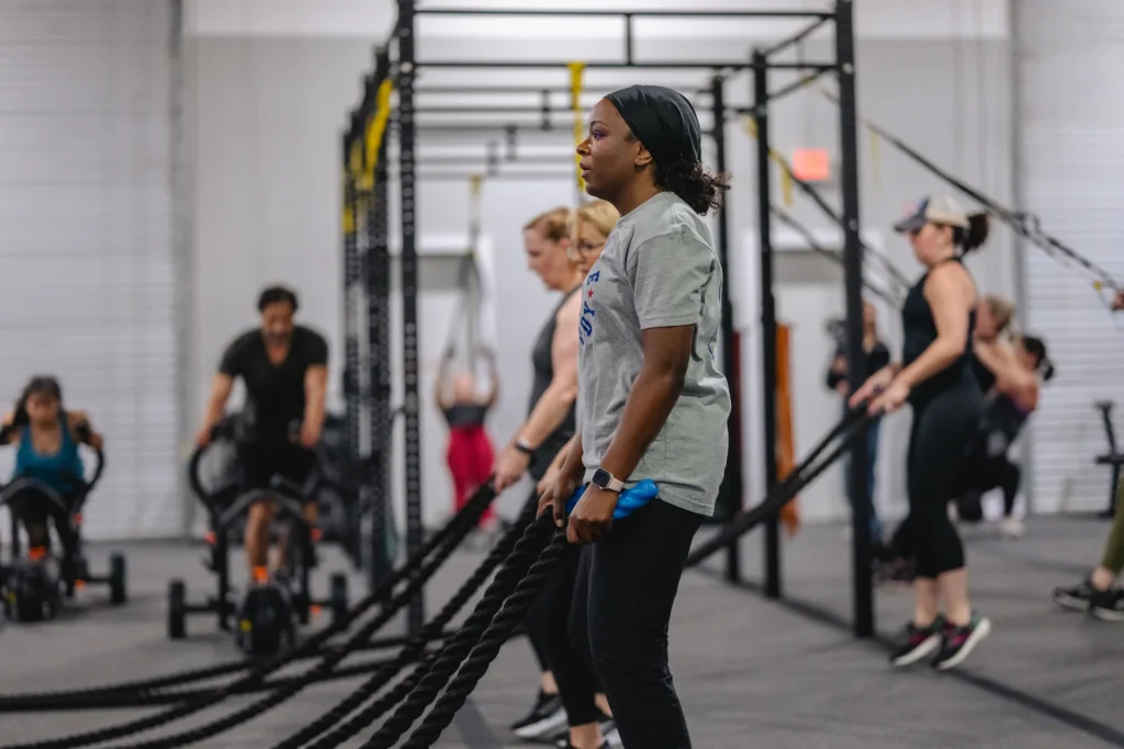 Fit Body Boot Camp class using battle ropes during a circuit workout.