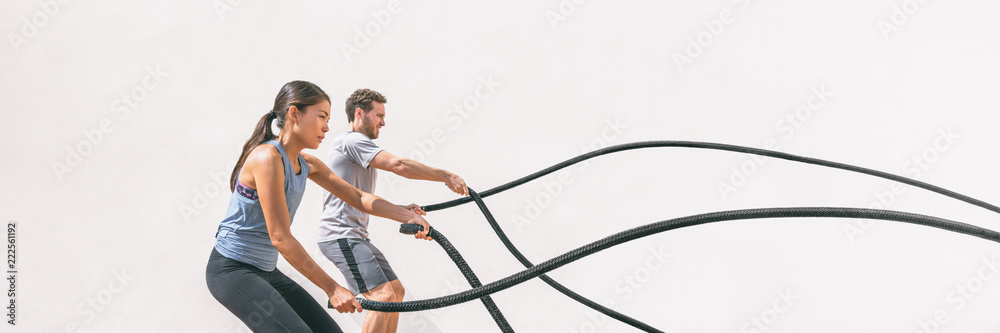 Gym fitness sport fit couple working out battle rope