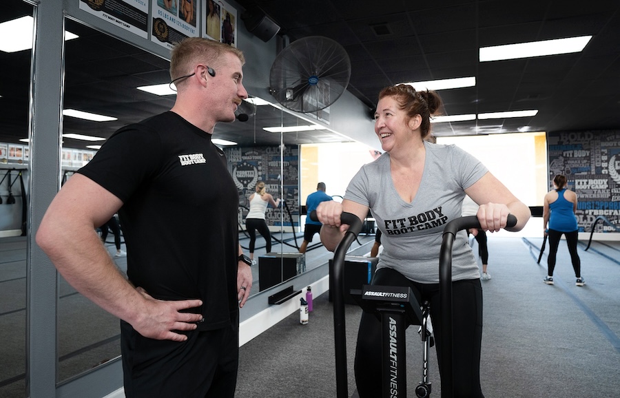 A woman on exercise bike in group fitness class.