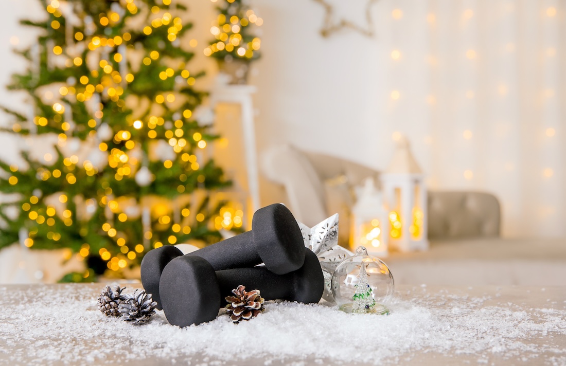 Exercise weights in front of a Christmas tree