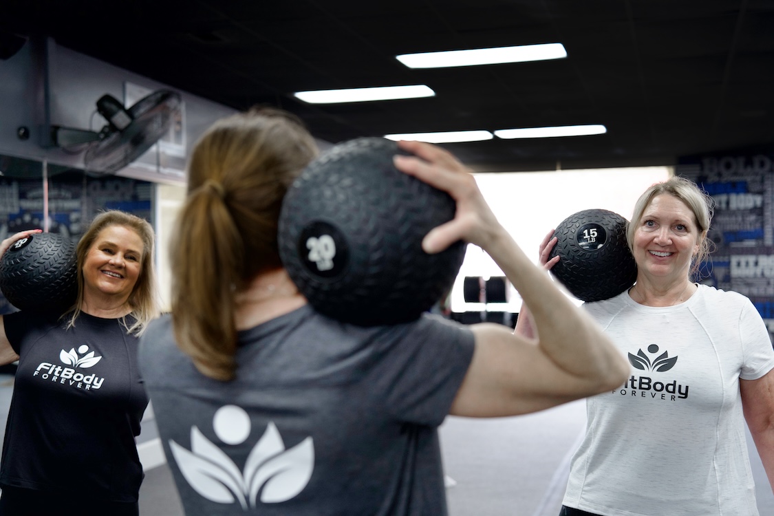 Group of women working out with weighted balls.