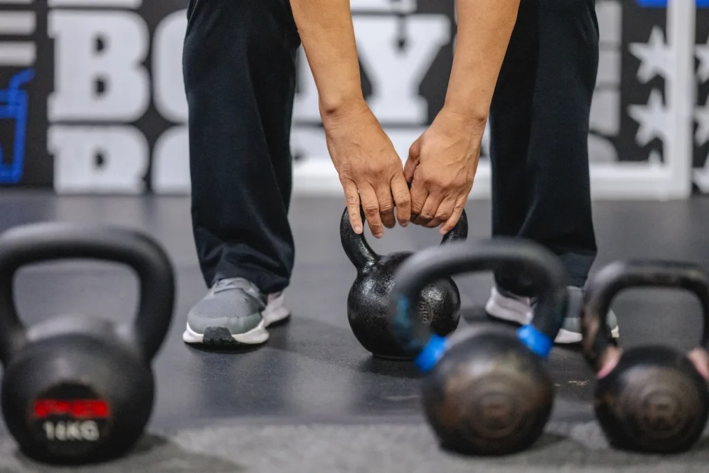 Person picking up a kettle bell during a Fit Body Boot Camp workout.