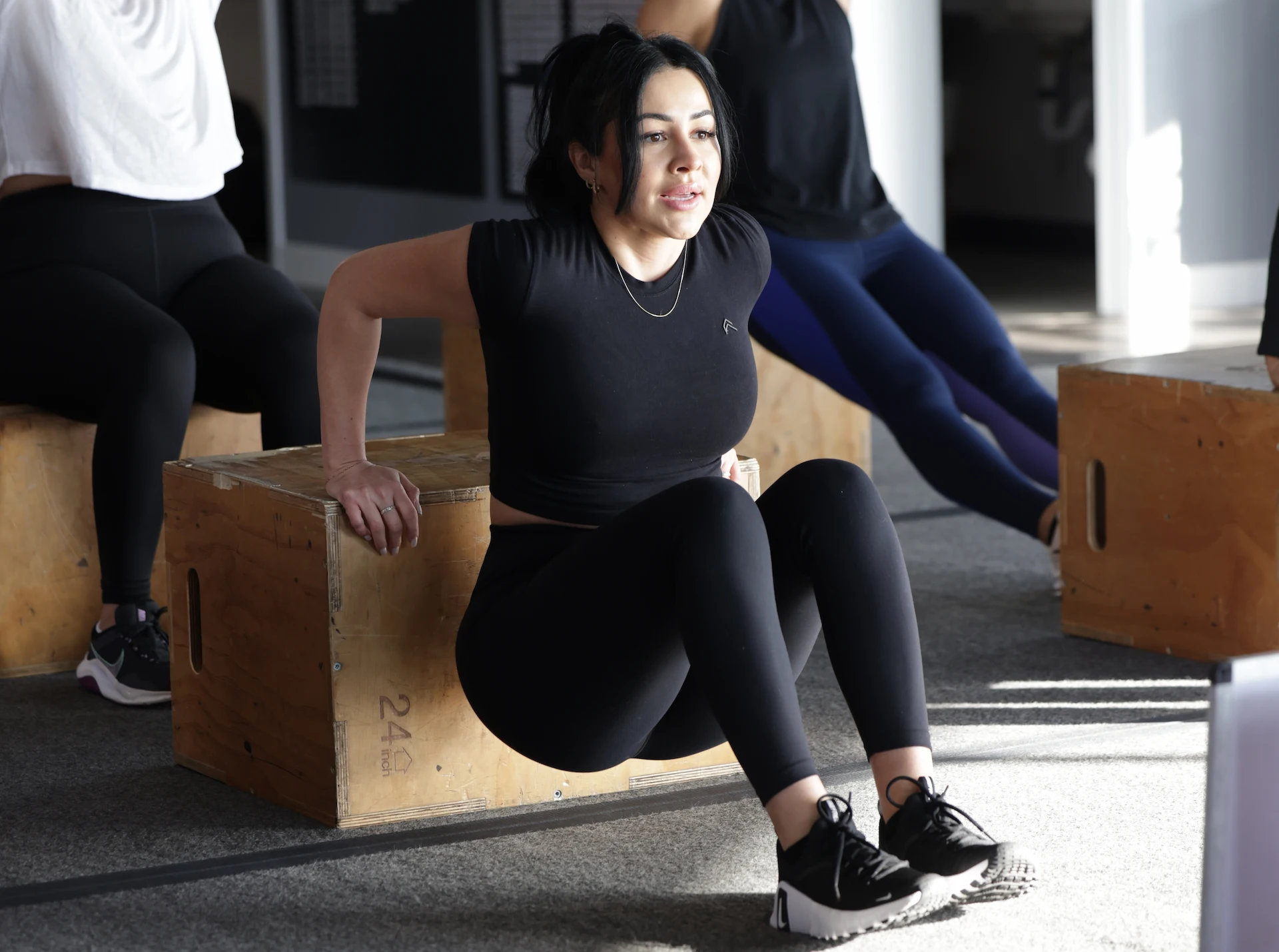 Woman performing tricep dips at a FBBC boot camp class.