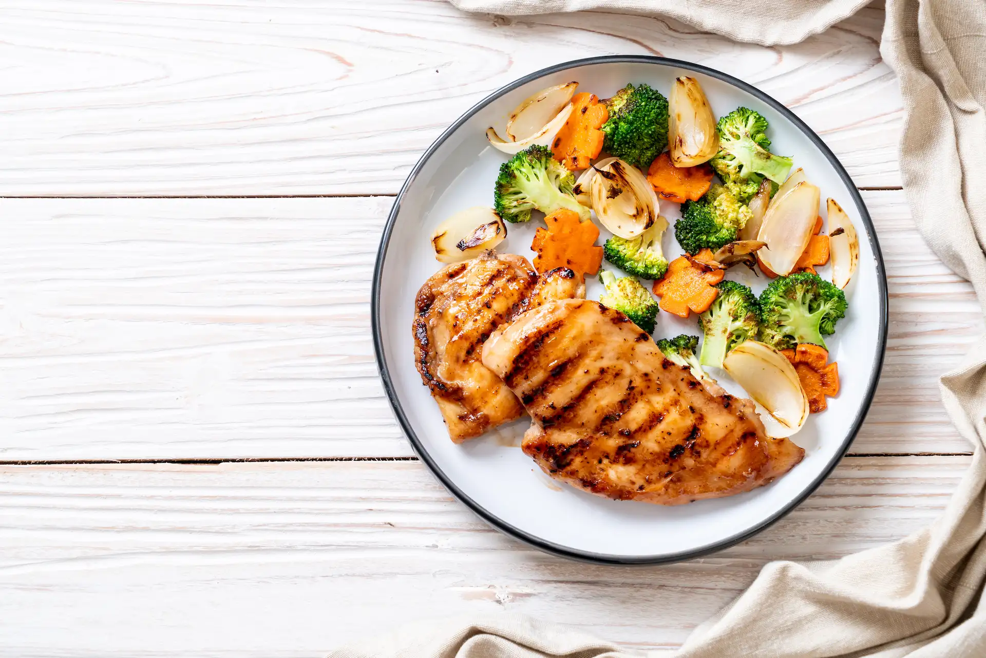 Healthy plate of food with chicken breast broccoli and carrots.