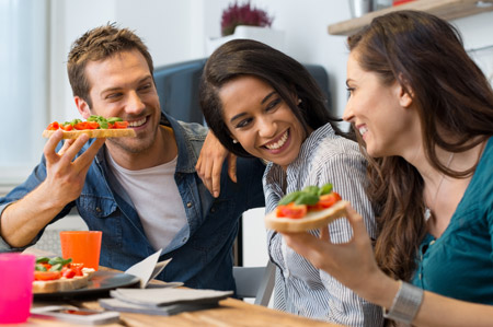 A group of three friends share a healthy dinner over conversation and laughs 